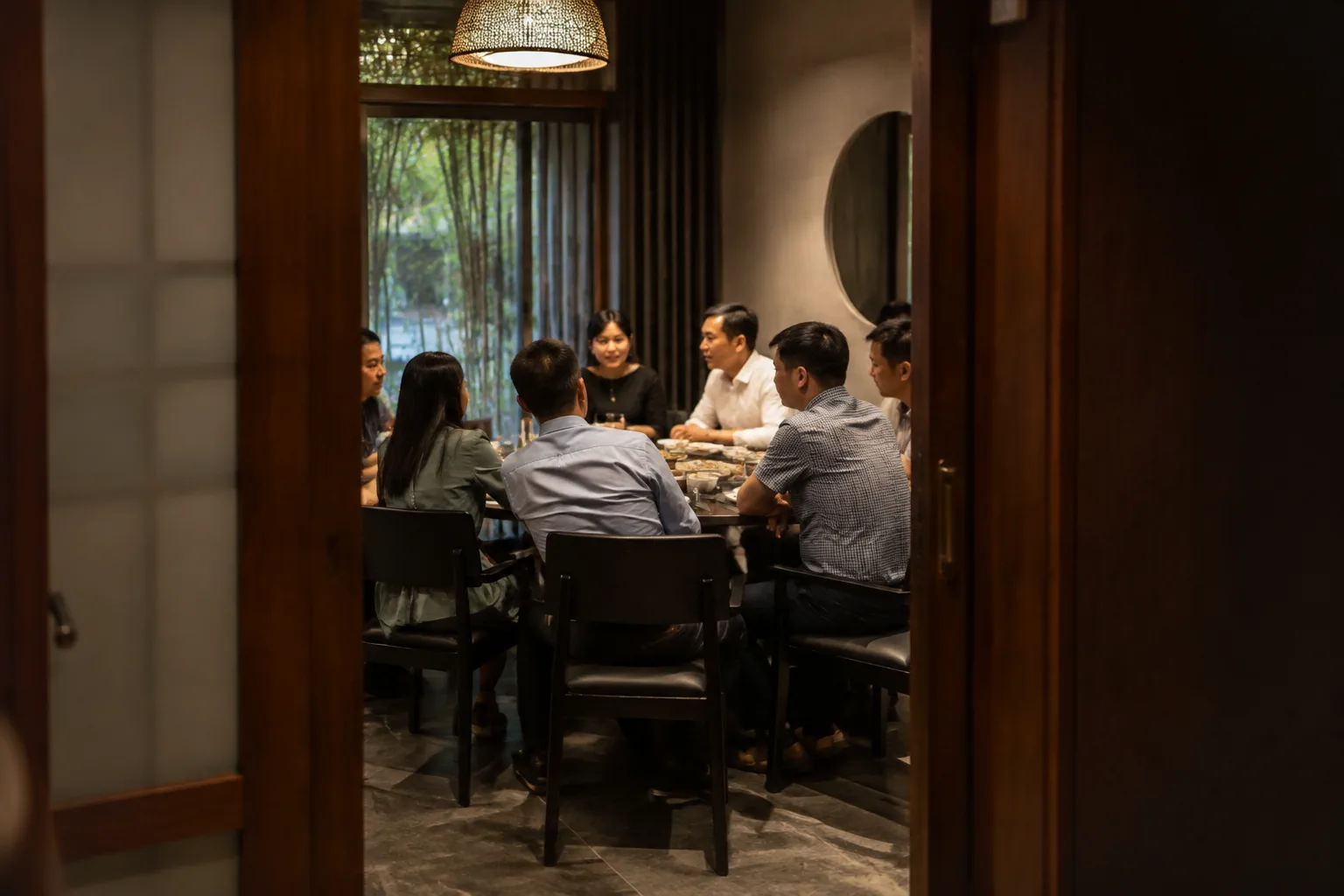 Khách Việt Nam đang trao đổi riêng tư trong một phòng ăn tách biệt của nhà hàng, với bàn ăn được chuẩn bị cho buổi gặp mặt nhỏ và không gian yên tĩnh tạo cảm giác thoải mái khi trò