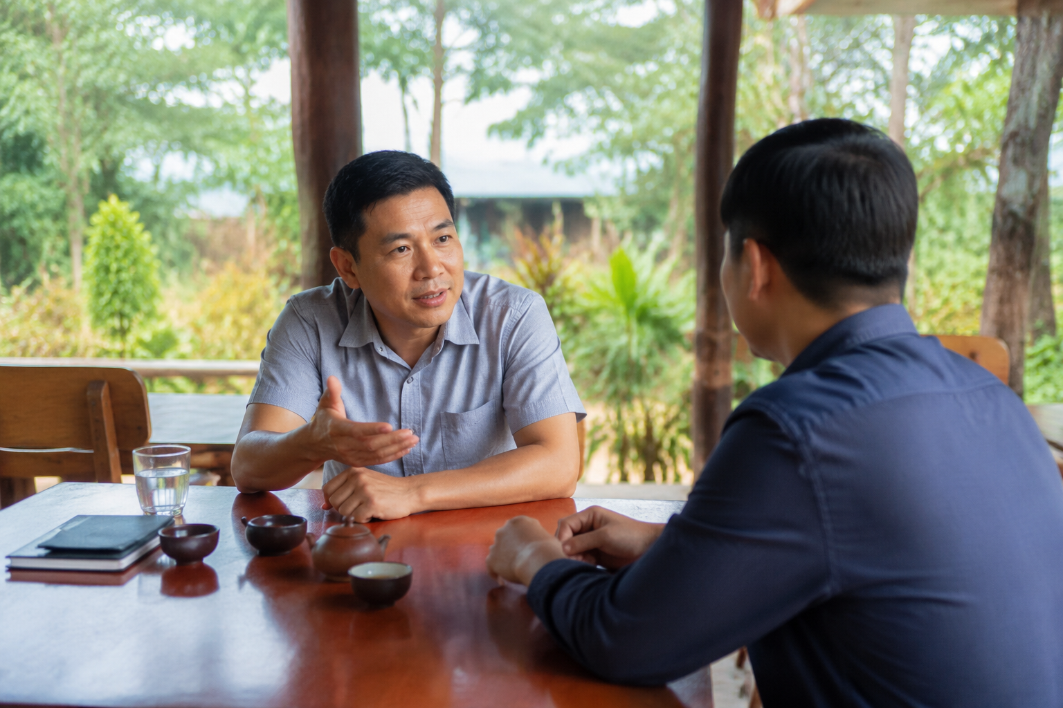Người mua và bên liên quan trao đổi kế hoạch giao dịch bất động sản tại không gian địa phương, thể hiện quá trình chuẩn bị và phối hợp khi mua đất từ xa