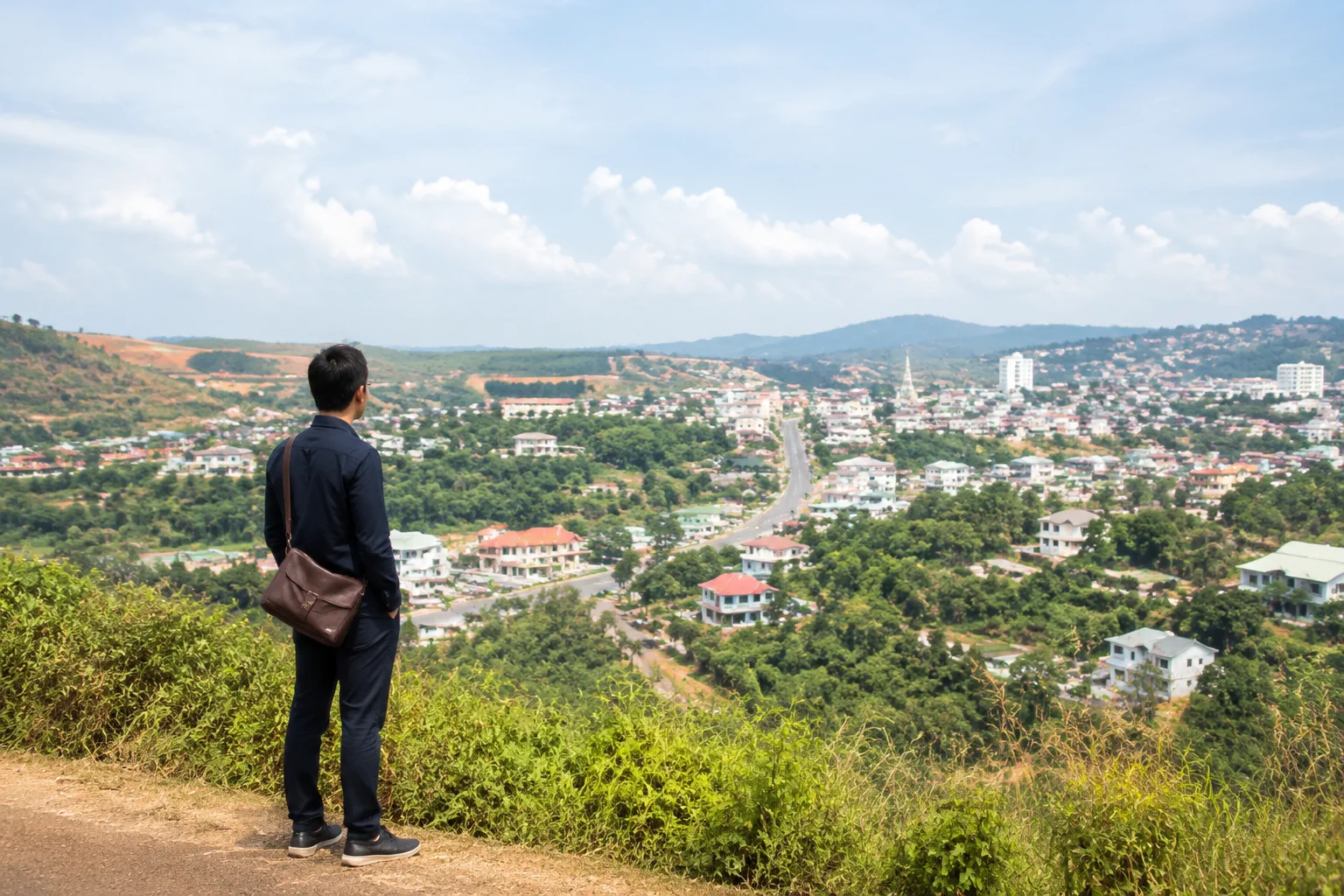 Người mua nhà đất ở xa đang quan sát thành phố Gia Nghĩa từ một điểm cao ven đô, kết hợp tìm hiểu không gian sống và khu vực xung quanh trước chuyến khảo sát thực tế.