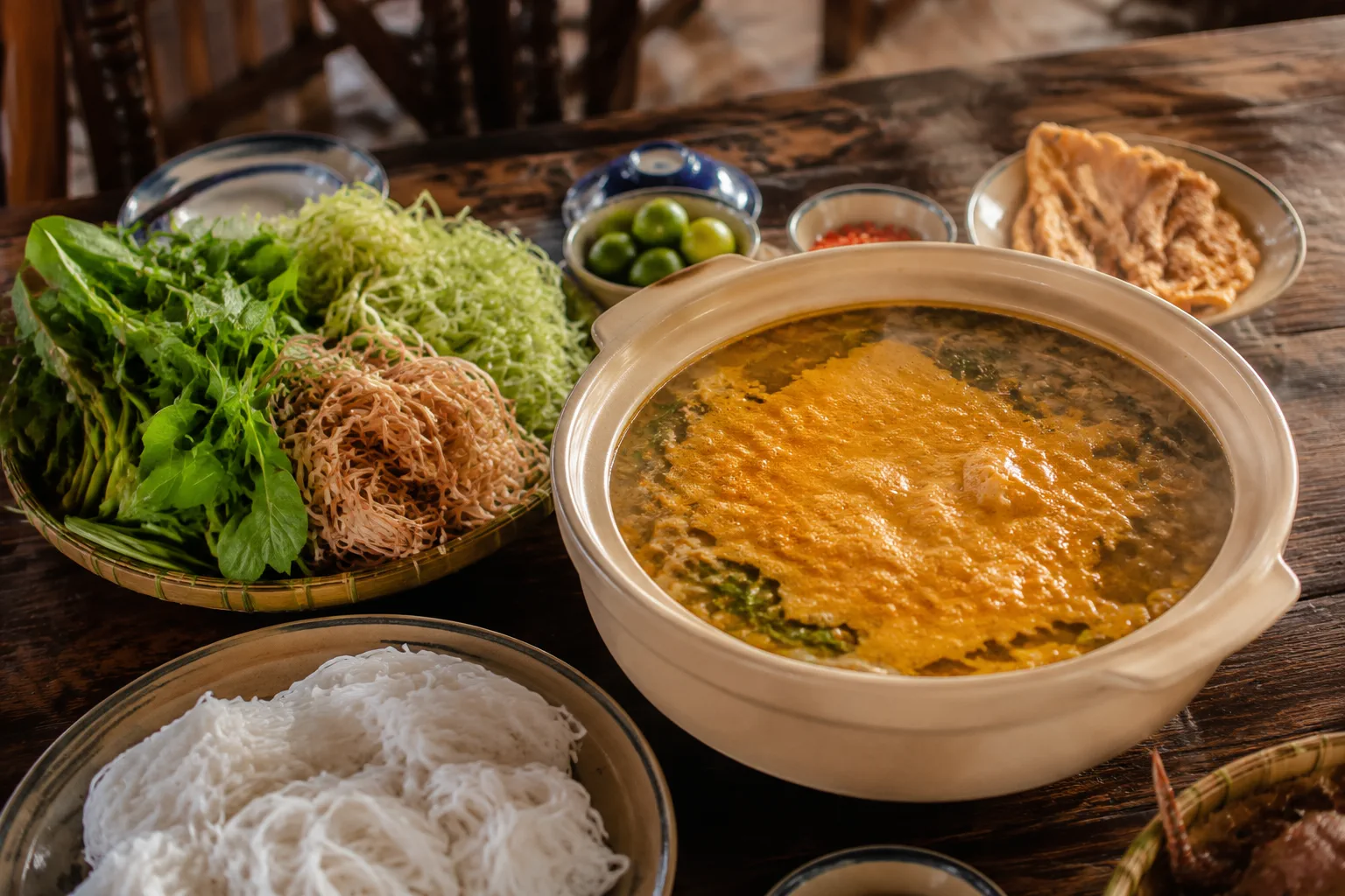 Nồi lẩu cua đồng hấp dẫn với gạch cua vàng óng và rau tươi tại không gian nhà hàng ấm cúng