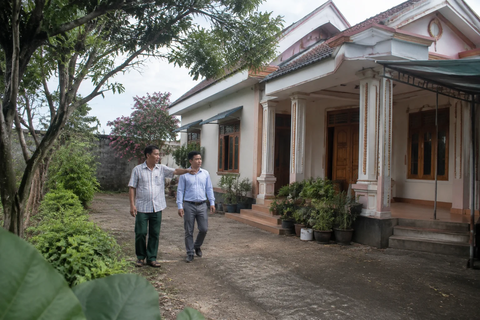 Chuyên viên bất động sản cùng chủ tài sản quan sát khu nhà tại Gia Nghĩa để trao đổi về hiện trạng và các đặc điểm cần cung cấp khi ký gửi, thể hiện bước khảo sát thực tế trước gia