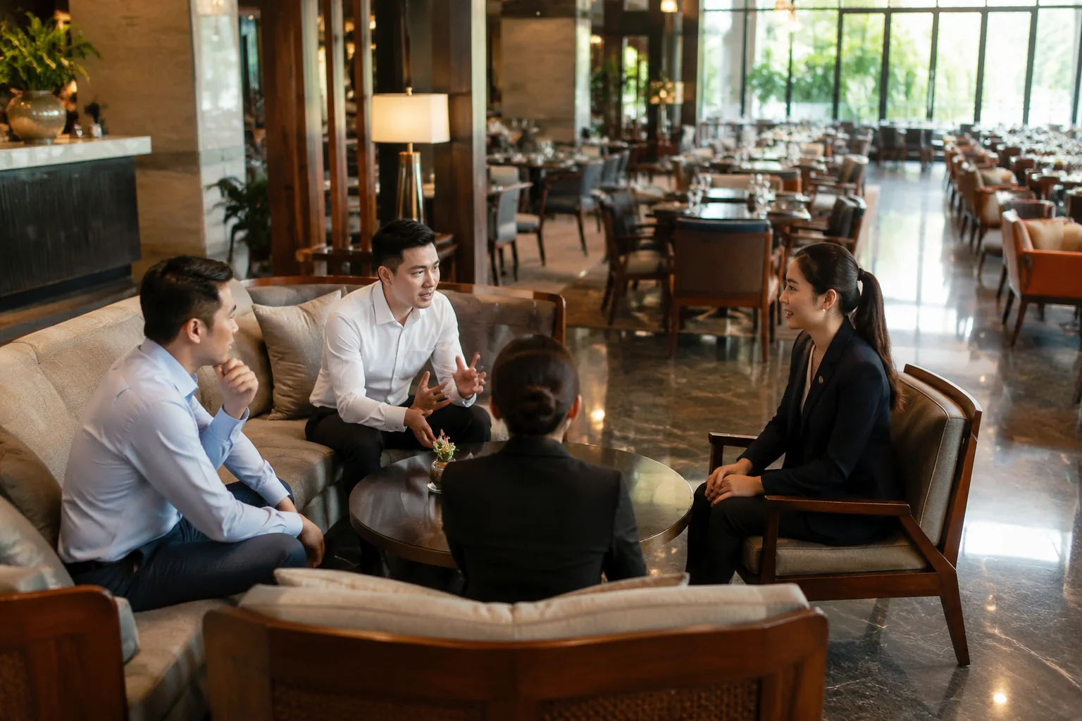 Toàn cảnh một buổi trao đổi chuẩn bị sự kiện tại nhà hàng Việt Nam với nhóm khách đang tham khảo không gian trước khi đặt dịch vụ, thể hiện quá trình xác định nhu cầu tổ chức.