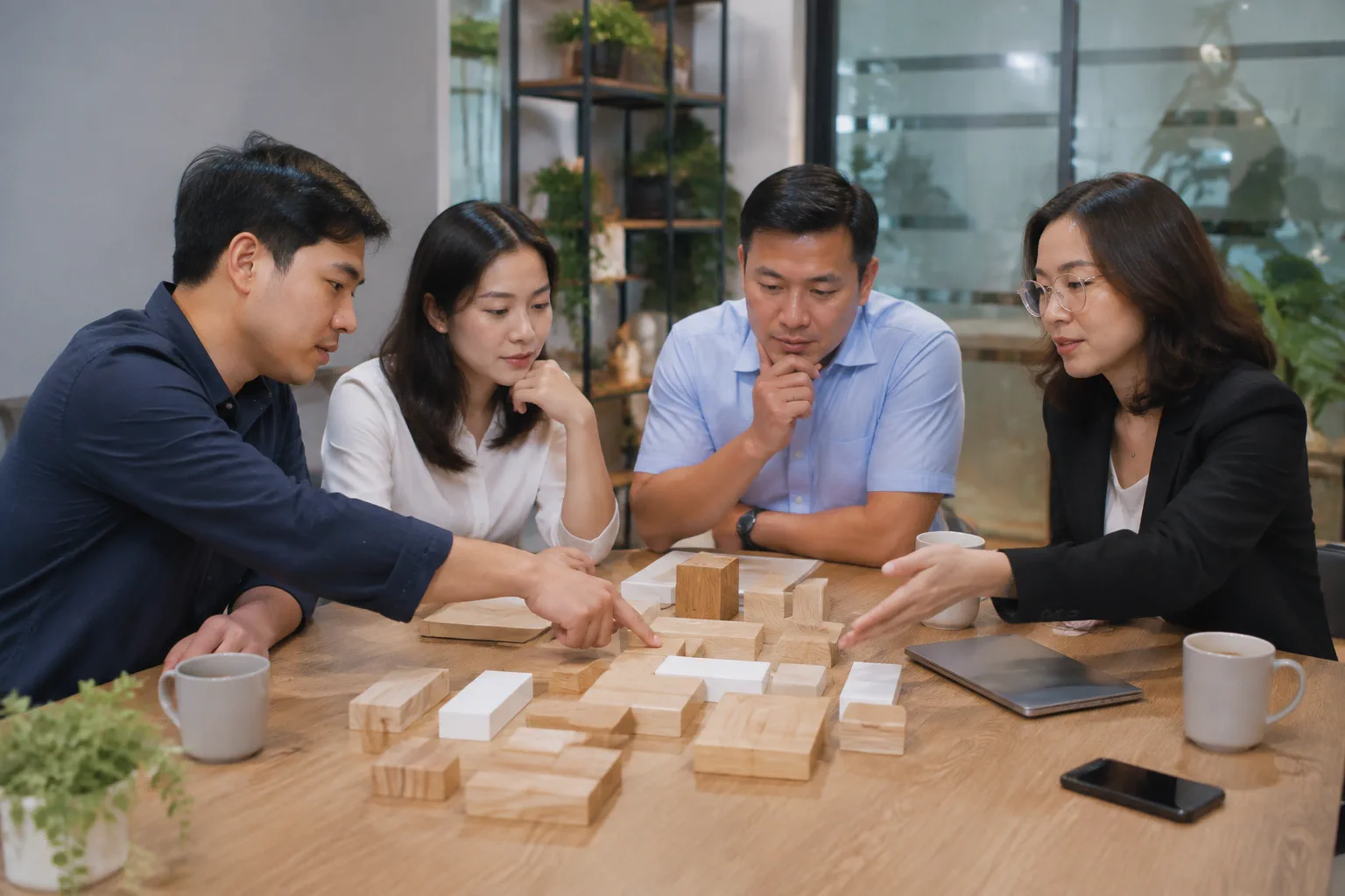 Góc nhìn cận cảnh đội ngũ doanh nghiệp Việt Nam trao đổi với chuyên gia web về khả năng mở rộng website trong tương lai bằng các mô hình trực quan không chữ trên bàn họp.