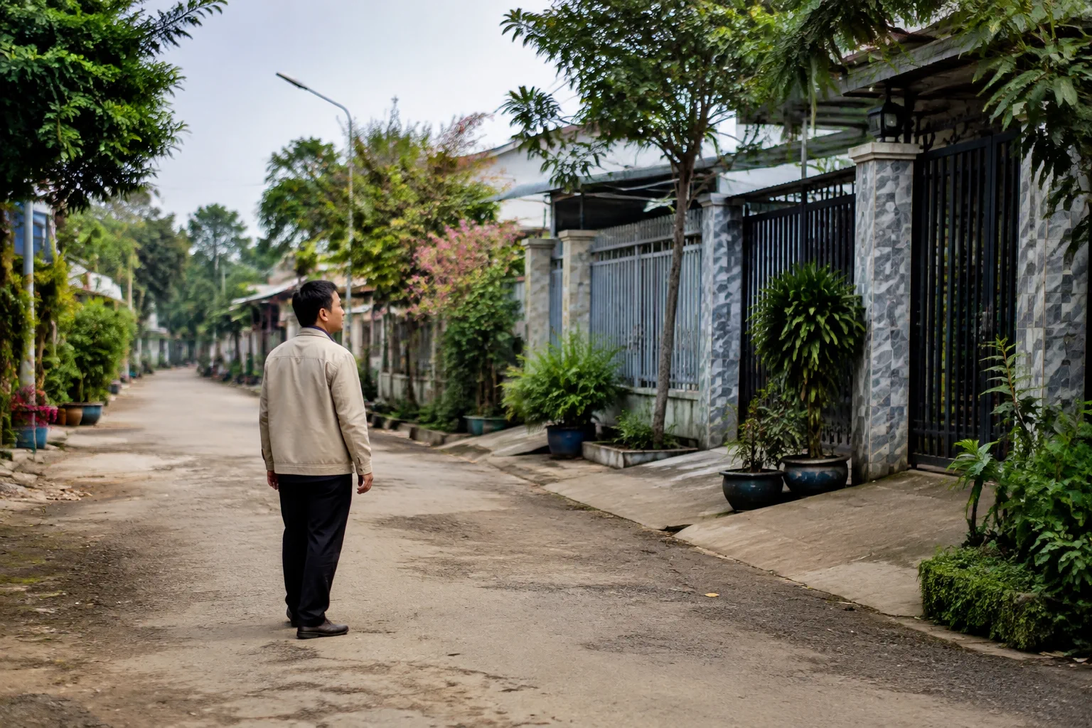 Một người mua nhà tại Gia Nghĩa đang đi bộ quanh khu dân cư yên tĩnh để quan sát khoảng cách giữa ngôi nhà, đường đi và môi trường xung quanh trước khi so sánh các lựa chọn tài sản