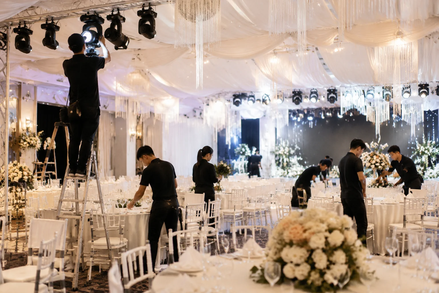 Đội ngũ nhân viên chuẩn bị hệ thống âm thanh ánh sáng và trang trí cho tiệc cưới tại Việt Nam
